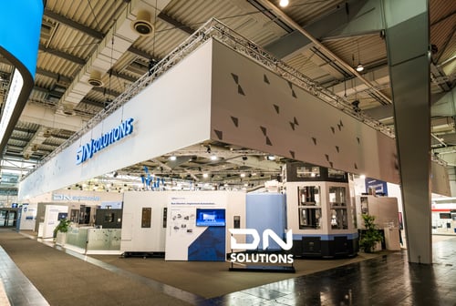 Messestand für DN SOLUTIONS mit barrierefreiem Zugang dank bodentiefer Bebauung.