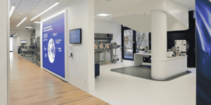 Moderne Präsentationsfläche auf einer Gesundheitsmesse mit integrierter Laborumgebung und digitalen Informationsdisplays für die Pharmaindustrie.