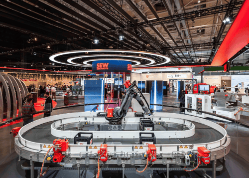 Supervision of the SEW-EURODRIVE stand at the Hannover Messe trade fair for mechanical engineering and automation, featuring a large area for machine demonstrations.
