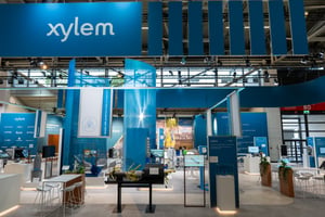 The xylem stand at IFAT in Munich, featuring blue tarpaulins hanging from the ceiling and information panels on the exhibition floor.