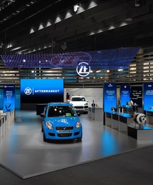 Aufsicht des ZF-Messestandes auf der Automechanika mit zwei ausgestellten Autos und LED-Displaywänden.