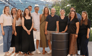 Gruppenfoto eines engagierten Teams vor modernem Hintergrund – gemeinsam für Innovation und nachhaltige Projekte.