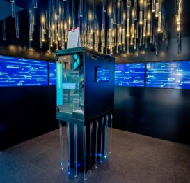 Detailaufnahme eines Siemens-Displays mit digitaler Stadtansicht und blauen LED-Lichtern. Im Vordergrund ist ein interaktiver Bildschirm zu sehen, der innovative Mobilitätslösungen präsentiert.